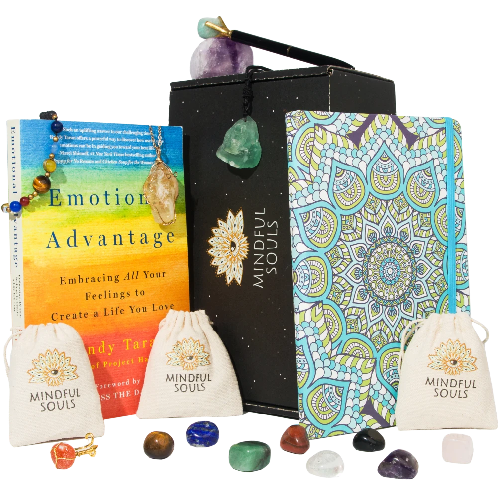 Mindful Souls subscription box featuring assorted spiritual items including healing crystals, jewelry, essential oils, and mindfulness accessories arranged in an open black box.